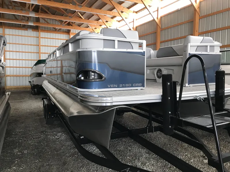 Slide: The Image of 2025 Avalon Venture Cruise Rear Bench pontoon boat in storage facility. - 22