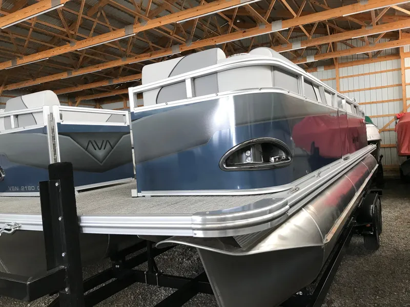 Slide: The Image of 2025 Avalon Venture Cruise Rear Bench pontoon boat in storage facility. - 23
