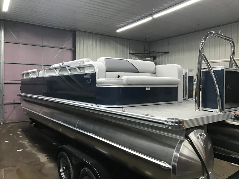 Slide: The Image of 2025 Avalon Venture Cruise Rear Bench 22' pontoon boat in a showroom setting. - 3