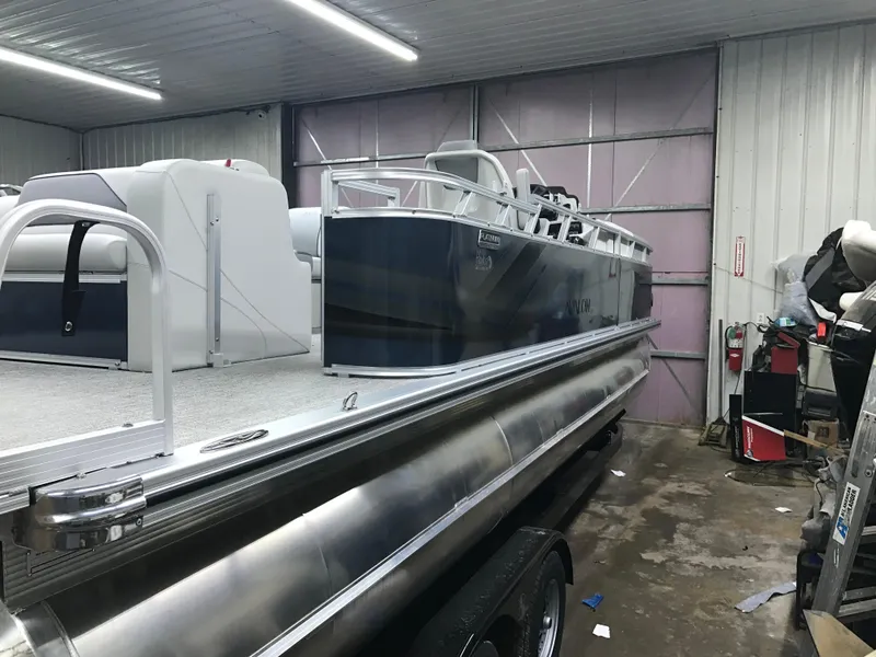 Slide: The Image of 2025 Avalon Venture Cruise Rear Bench pontoon boat in a garage setting. - 4