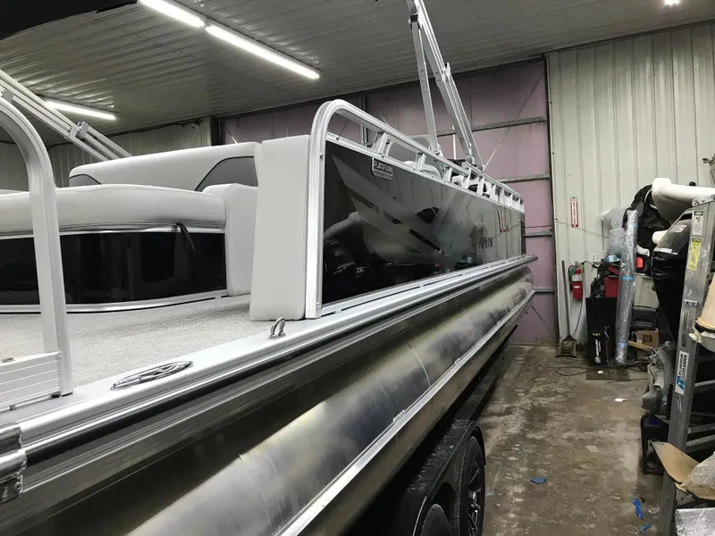 Slide: The Image of 2025 Avalon VENTURE 2585 Versatile Rear Bench pontoon boat in a garage. - 7