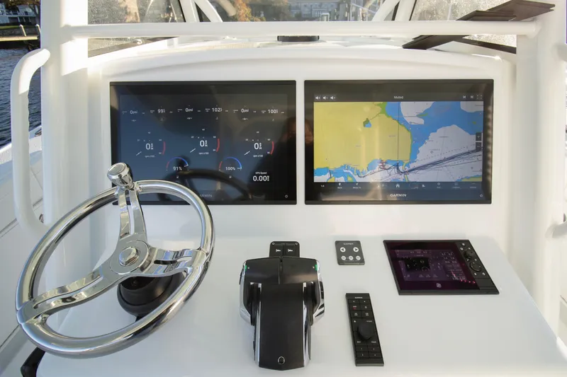 Slide: The Image of 2024 Yellowfin 39 boat dashboard with dual navigation screens and steering wheel. - 29