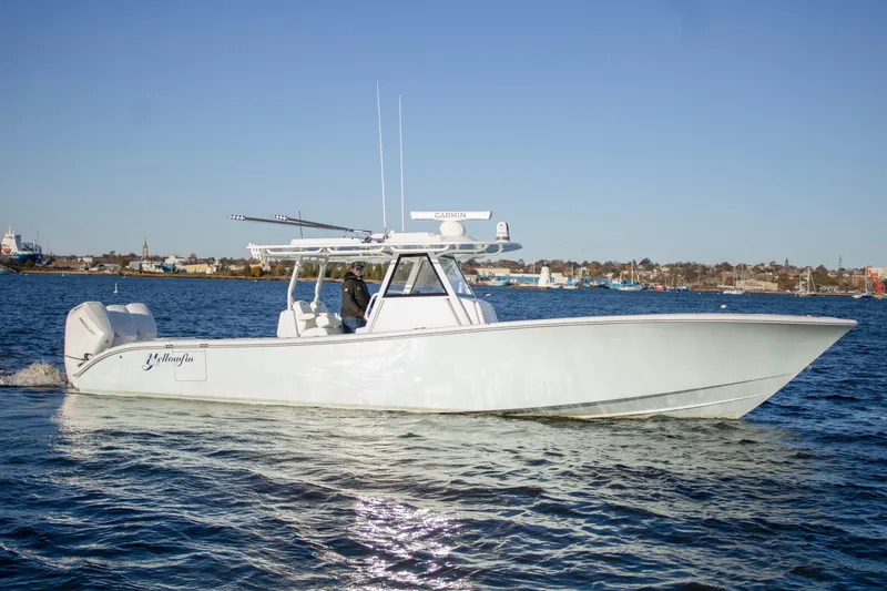 Slide: The Image of 2024 Yellowfin 39 boat cruising on calm water under clear blue sky. - 9