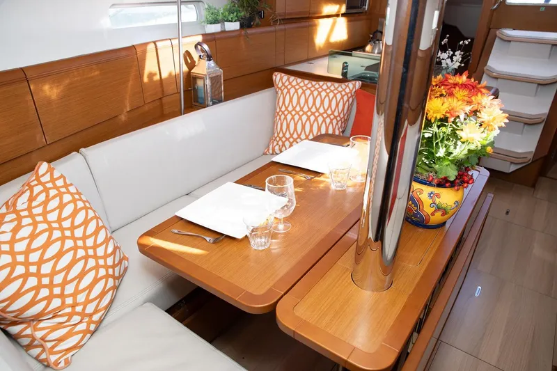Slide: The Image of Elegant interior of 2020 Jeanneau Sun Odyssey 389 yacht with dining area and floral centerpiece. - 2