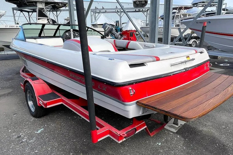 Slide: The Image of 1999 Malibu Response LX boat with red and white design on a trailer. - 2