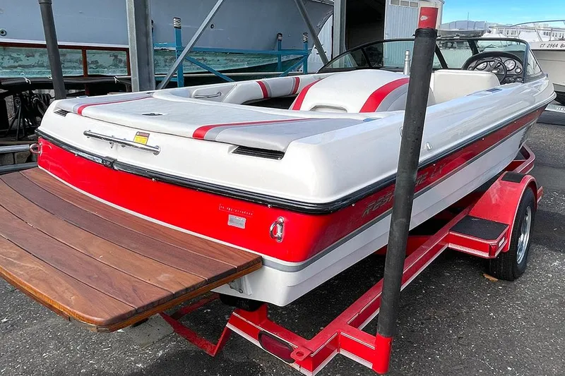 Slide: The Image of 1999 Malibu Response LX boat with red and white design on a trailer. - 4