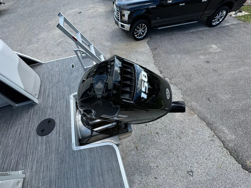 Slide: The Image of 2025 Sweetwater 2286 SB boat with 150 HP outboard motor, parked on pavement. - 11