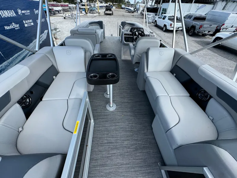 Slide: The Image of 2025 Sweetwater 2286 SB pontoon boat interior with gray seating and central table. - 13