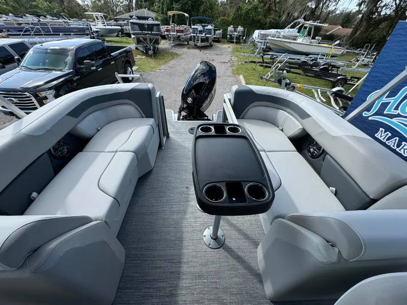 Slide: The Image of 2025 Sweetwater 2286 SB pontoon boat interior with gray seating and central table. - 9