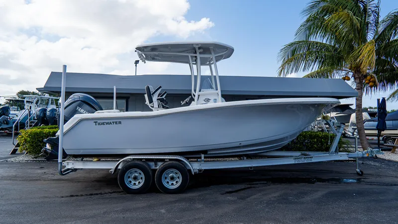 Slide: The Image of 2025 Tidewater 220 CC Adventure boat on trailer, parked near palm tree. - 12