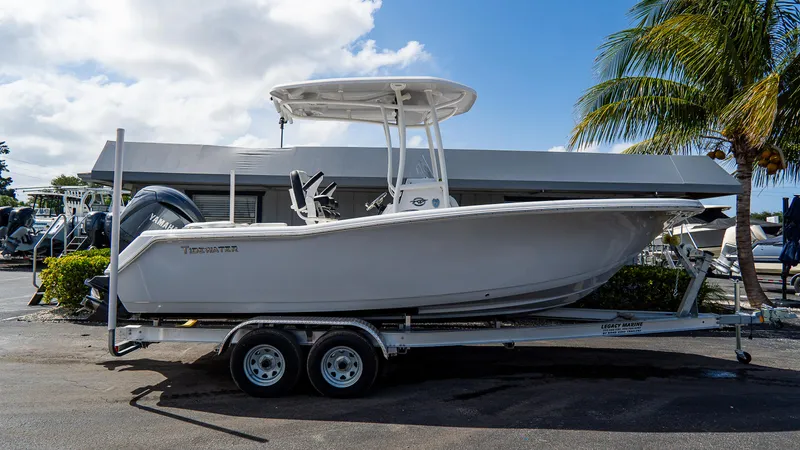 Slide: The Image of 2025 Tidewater 220 CC Adventure boat on trailer, parked outdoors under a clear sky. - 15