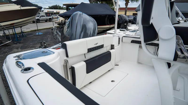 Slide: The Image of 2025 Tidewater 220 CC Adventure boat interior with seating and motor, in a marina setting. - 5