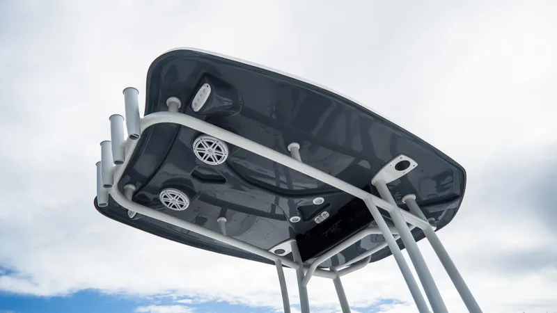 Slide: The Image of 2025 Tidewater 220 CC Adventure boat top view with speakers and rod holders against cloudy sky. - 8