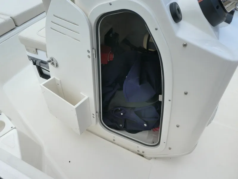 Slide: The Image of Storage compartment on a 2025 Boston Whaler 150 Montauk boat, open with gear inside. - 6
