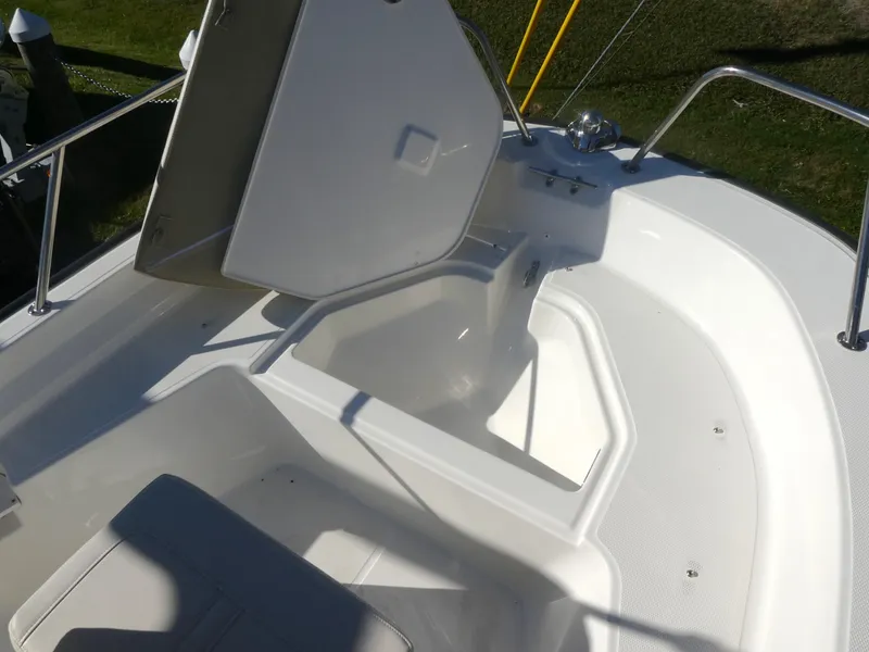 Slide: The Image of 2025 Boston Whaler 150 Montauk boat interior with open storage compartment. - 8