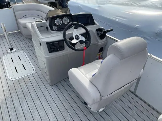 Slide: The Image of 2023 SunCatcher Select 324RC boat interior with steering console and seating. - 9