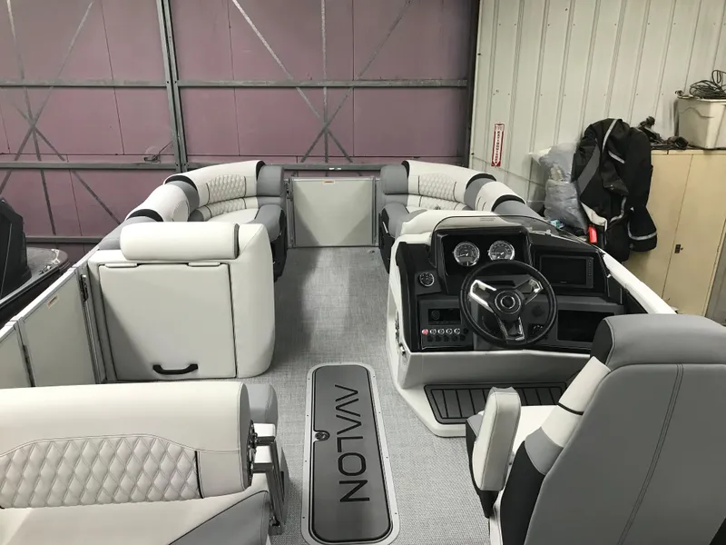 Slide: The Image of 2025 Avalon Catalina boat interior with modern seating and steering console in a garage setting. - 12