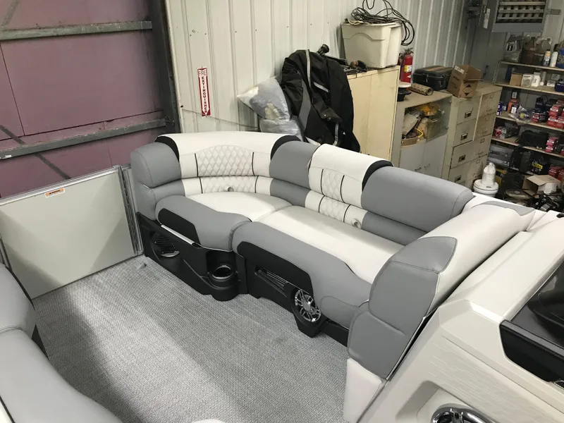 Slide: The Image of 2025 Avalon Catalina boat interior with plush gray seating in a garage setting. - 16