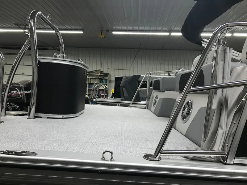 Slide: The Image of 2025 Avalon Catalina boat interior with sleek seating and modern design in a well-lit garage. - 6