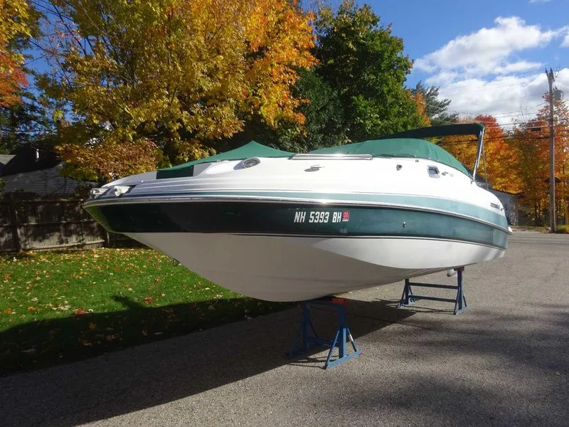 Slide: The Image of 2002 Four Winns 234 Funship boat on stands, surrounded by autumn trees. - 1