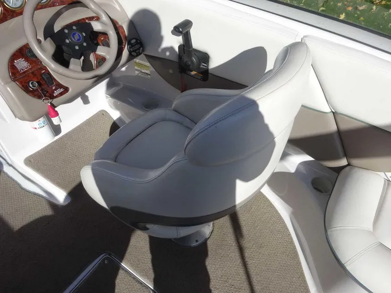 Slide: The Image of Interior of 2002 Four Winns 234 Funship boat with white seating and steering wheel. - 10