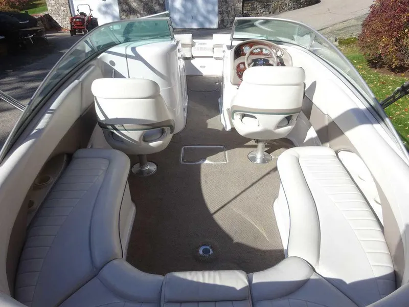 Slide: The Image of Interior of 2002 Four Winns 234 Funship boat with white seating and steering wheel. - 12