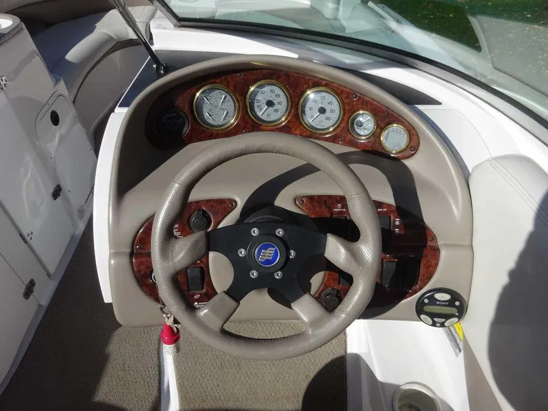 Slide: The Image of 2002 Four Winns 234 Funship boat dashboard with steering wheel and gauges. - 17