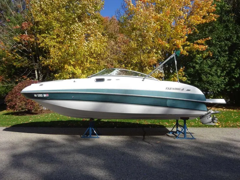 Slide: The Image of 2002 Four Winns 234 Funship boat on stands, surrounded by autumn trees. - 2