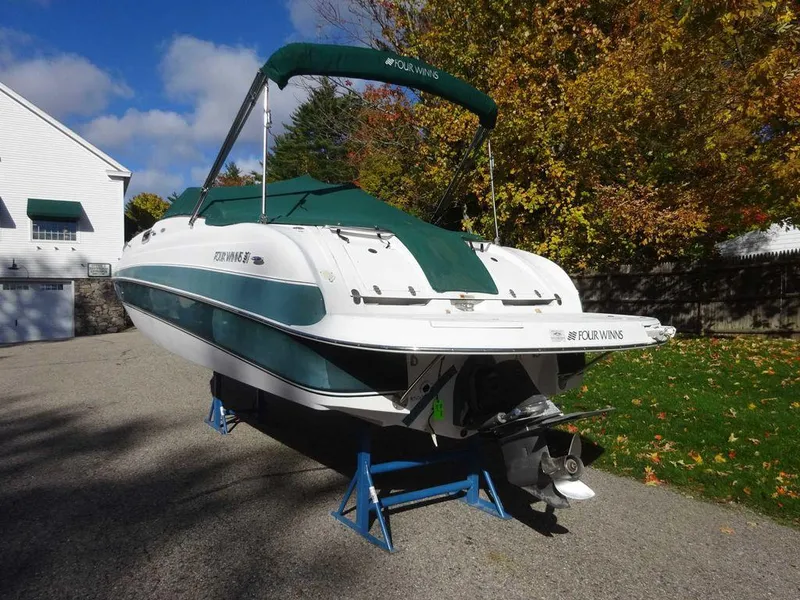 Slide: The Image of 2002 Four Winns 234 Funship boat on stands, green and white cover, driveway setting. - 3