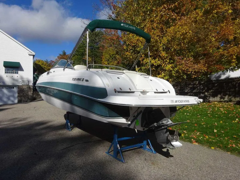 Slide: The Image of 2002 Four Winns 234 Funship boat on stands, surrounded by autumn foliage. - 4