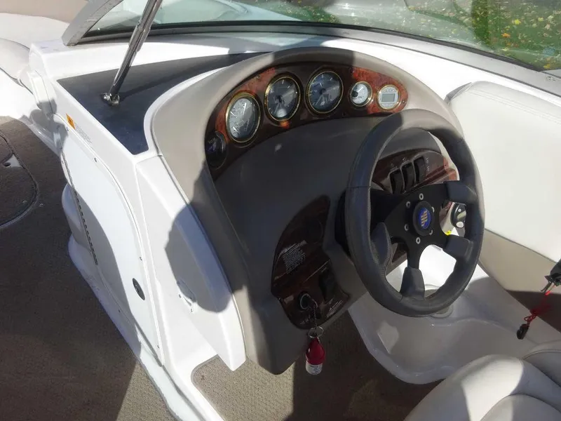 Slide: The Image of 2002 Four Winns 234 Funship boat dashboard with steering wheel and gauges. - 8