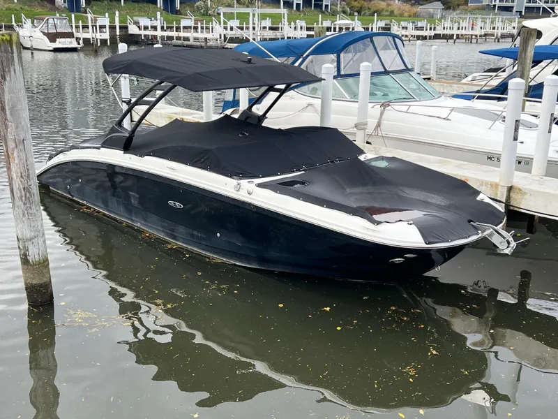 Slide: The Image of 2022 Sea Ray SDX 290 boat docked with black cover and canopy. - 2