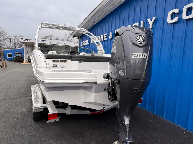Slide: The Image of 2025 Chaparral 23 SSi OB boat with Yamaha 200 engine, parked outside a blue building. - 4