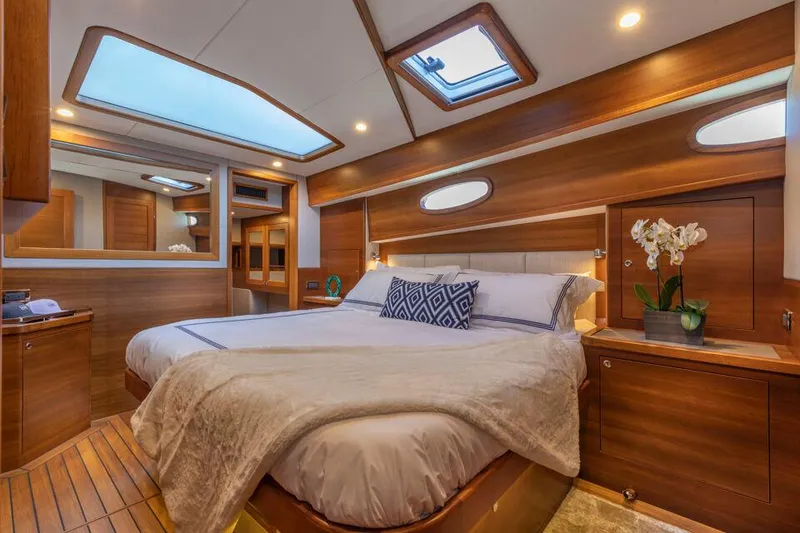 Slide: The Image of Luxurious Eastbay EB60 2025 yacht bedroom with elegant wood finish and skylight. - 26