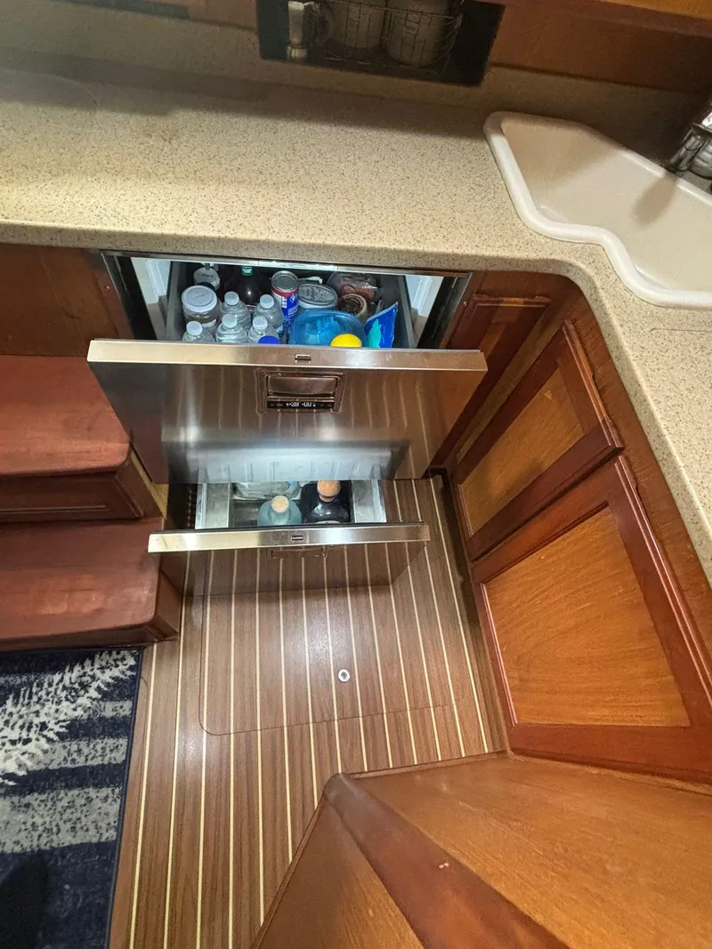 Slide: The Image of 2006 Luhrs 41 Open yacht kitchen with open fridge drawers and wood flooring. - 23