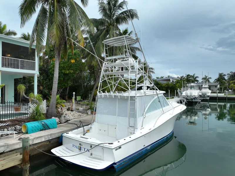 Slide: The Image of 2006 Luhrs 41 Open yacht docked by palm trees in a serene canal. - 9