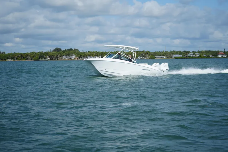 The Image of 2025 Twin Vee 240 GFX DC boat cruising on open water under a cloudy sky. - 0