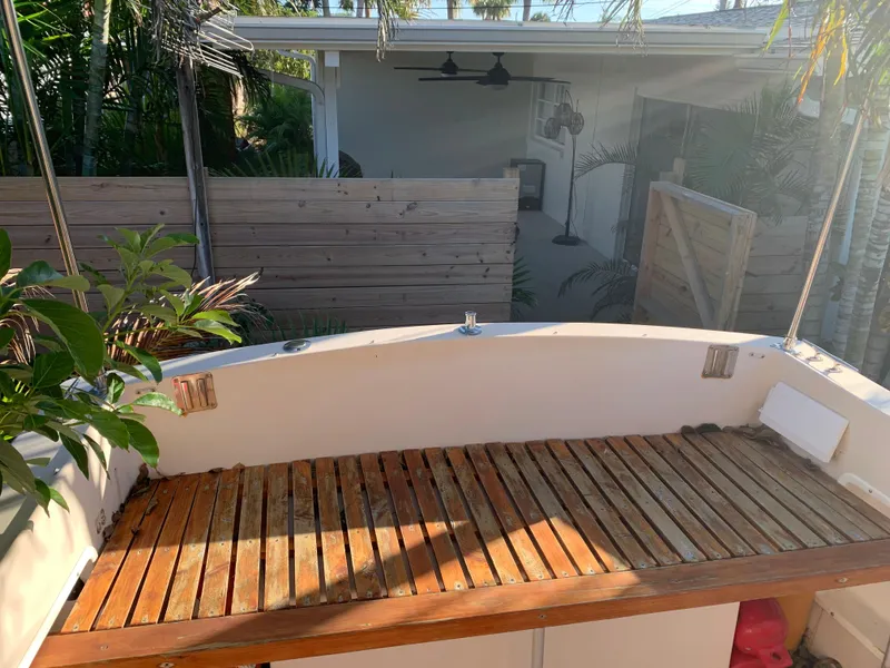 Slide: The Image of Wooden deck of a 1998 Atlas Acadia boat, surrounded by tropical plants. - 12
