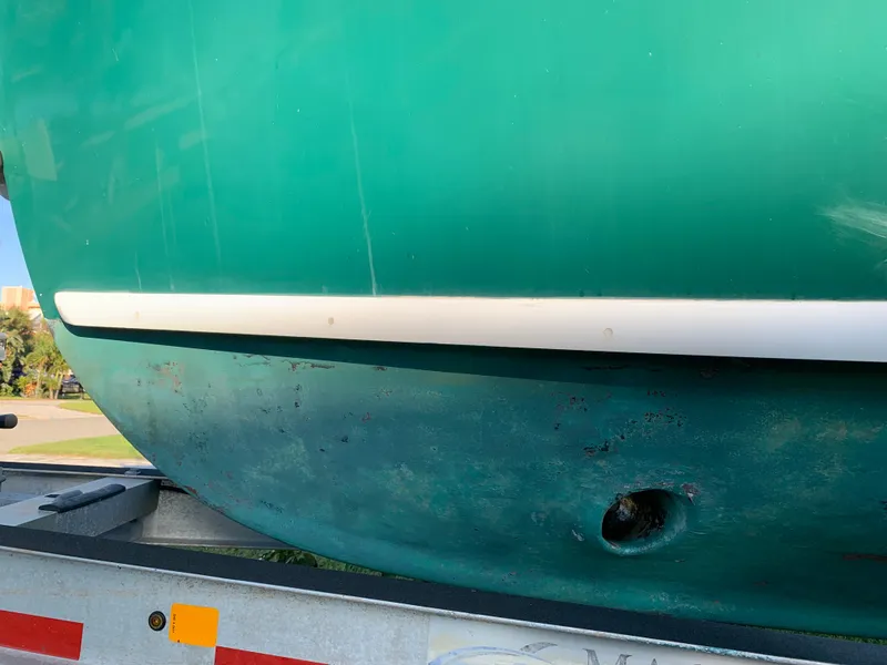 Slide: The Image of Green hull of a 1998 Atlas Acadia boat on a trailer. - 15
