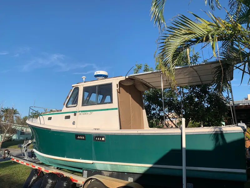 Slide: The Image of 1998 Atlas Acadia boat on trailer under palm trees. - 6