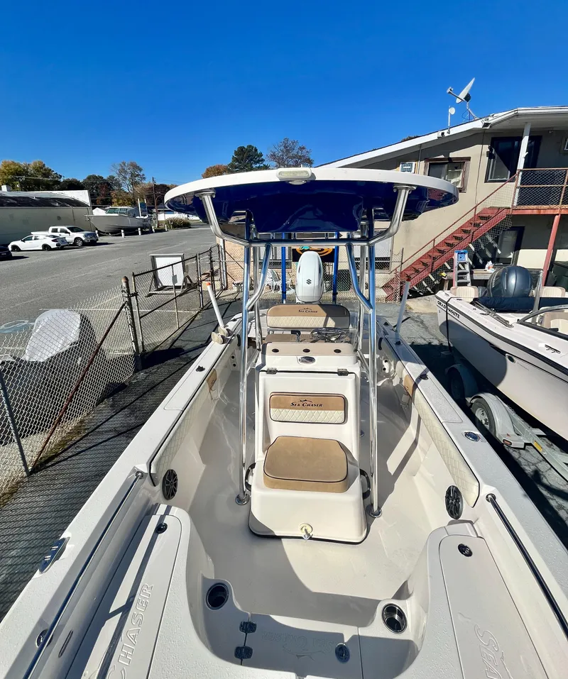 Slide: The Image of 2023 Sea Chaser 23 LX boat with blue canopy, docked in a marina. - 13