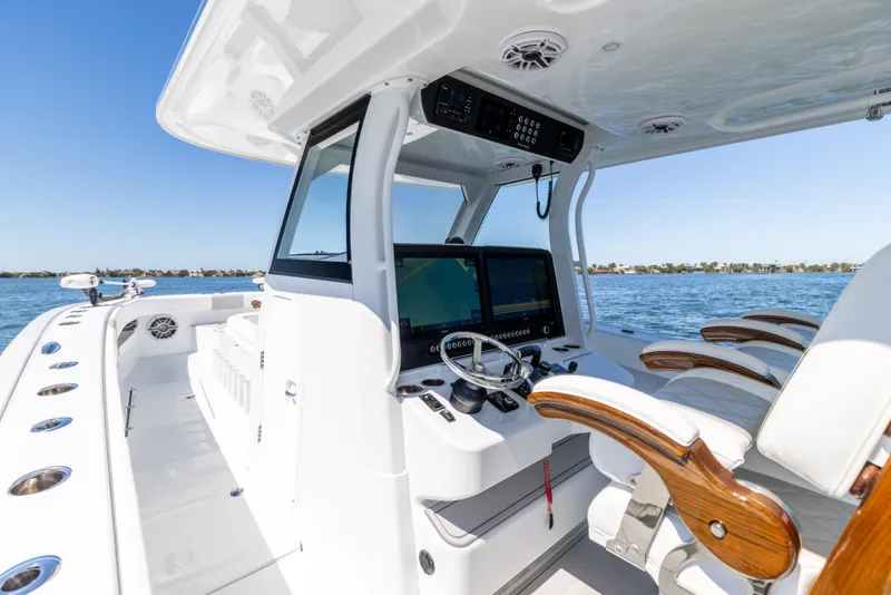Slide: The Image of 2023 Freeman 43 boat interior with modern helm and dual screens on open water. - 40