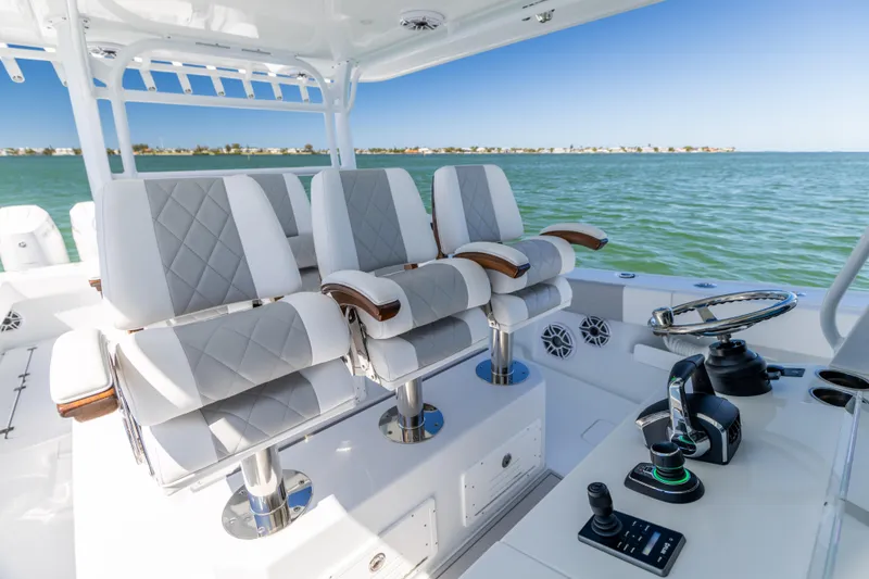 Slide: The Image of Luxury seating and controls on a 2023 Freeman 43 boat, overlooking calm waters. - 44