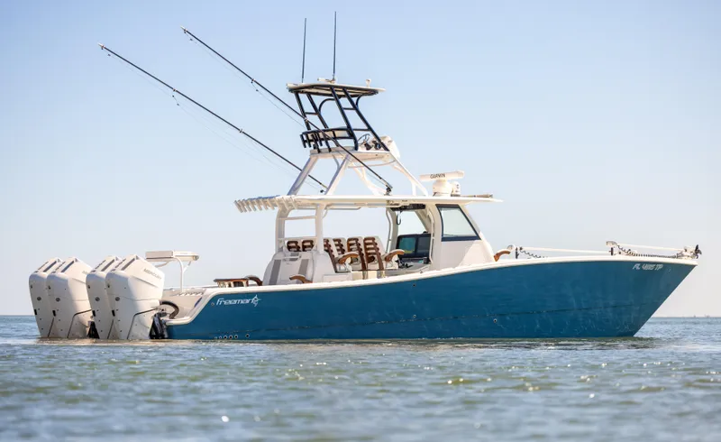 Slide: The Image of 2023 Freeman 43 boat with triple outboard engines on calm water. - 5