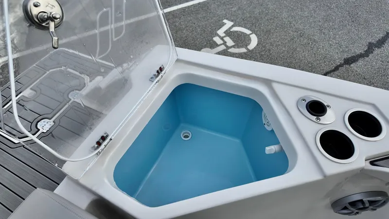 Slide: The Image of 2025 Starcraft SVX 231 OB CC boat compartment with cup holders and open storage. - 10