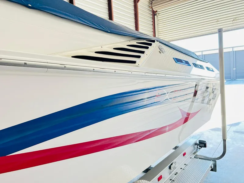 Slide: The Image of 2005 Fountain 42 Executioner boat with blue and red stripes in a garage. - 12