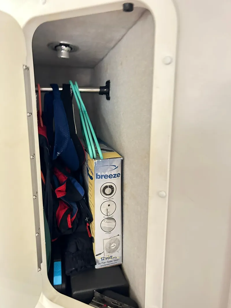 Slide: The Image of Storage compartment in a 2005 Fountain 42 Executioner boat with cleaning supplies and clothing. - 21