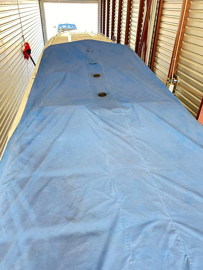 Slide: The Image of 2005 Fountain 42 Executioner boat covered in blue tarp inside storage unit. - 24