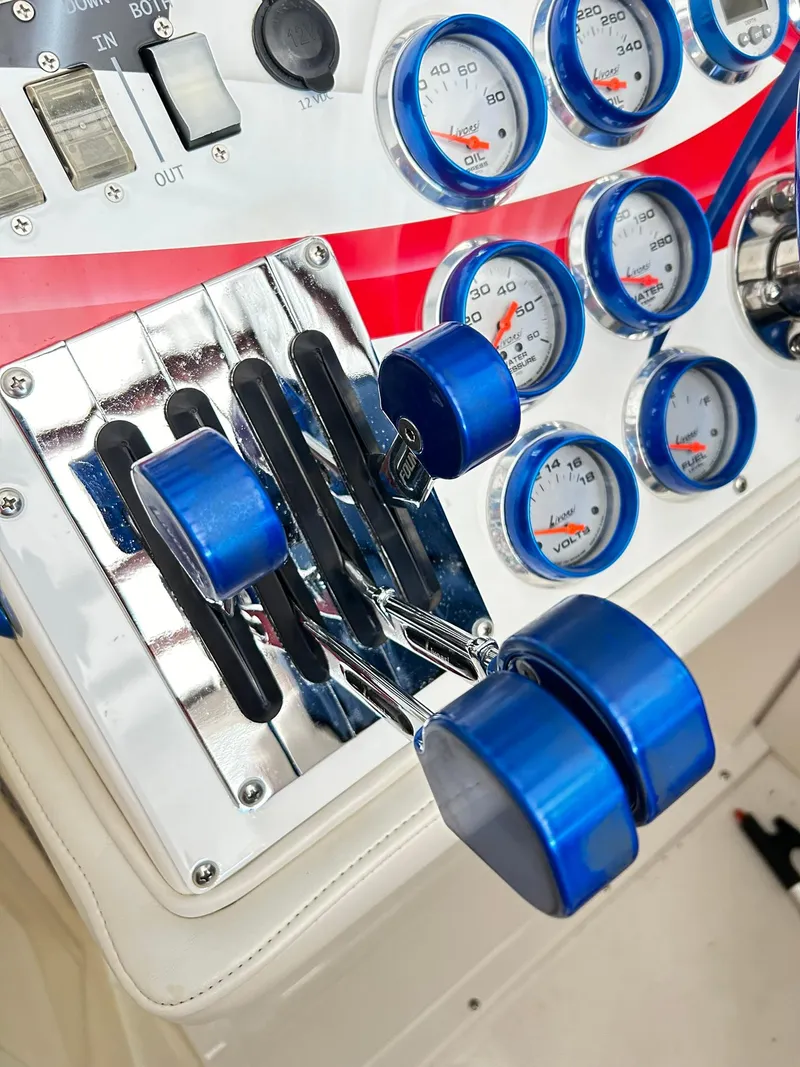 Slide: The Image of Control panel of a 2005 Fountain 42 Executioner boat with blue throttle levers and gauges. - 26