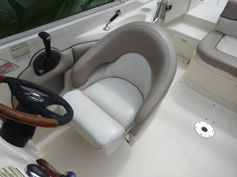 Slide: The Image of 2004 Sea Ray 220 Sundeck helm with steering wheel and comfortable seating. - 10